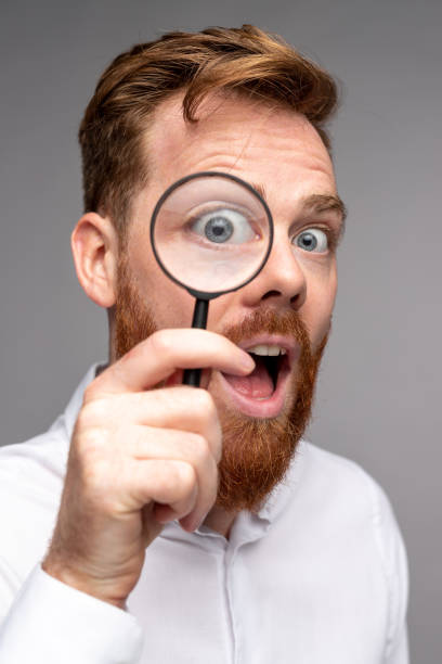 istock Curious man with magnifying glass 1309569198