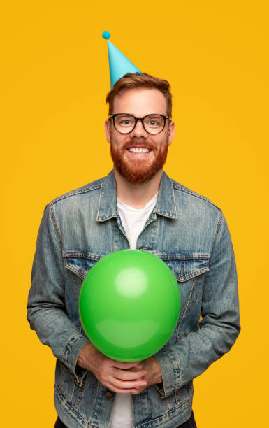 istock Happy young man with birthday balloon 1309569219