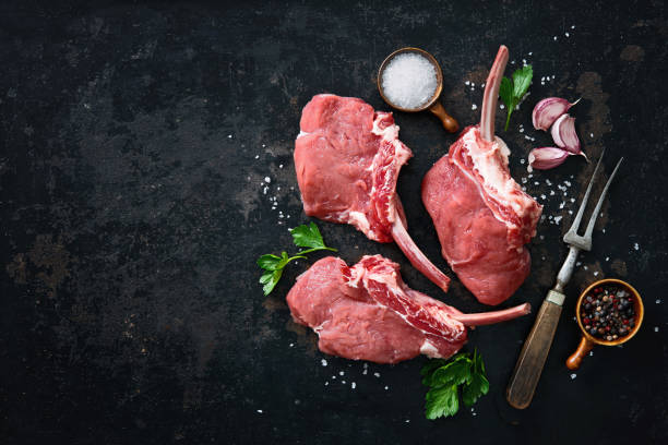 carne de ternero crudo con ingredientes de fondo rústico oscuro - veal rack fotografías e imágenes de stock