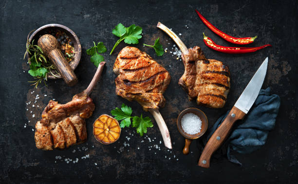 istock Grilled veal meat ribs cutlets with ingredients on rustic dark background 1309569569