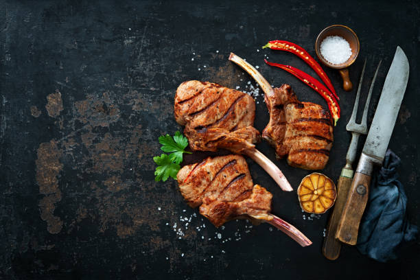 istock Grilled veal meat ribs cutlets with ingredients on rustic dark background 1309569578