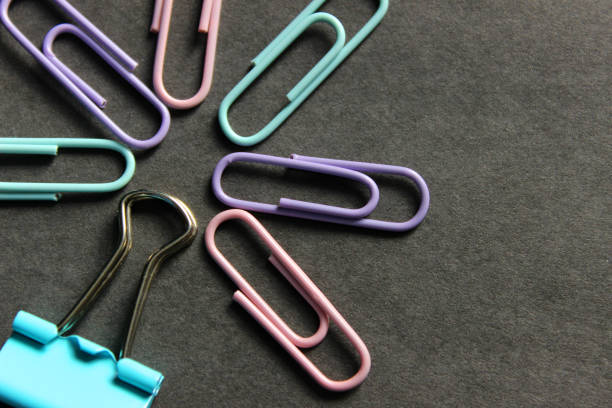 istock Multicolored paper clips on a dark background. 1309570487