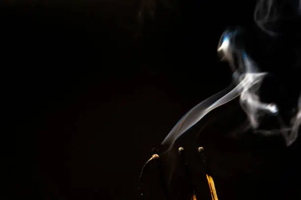 Photo of several burnt matches with white smoke on a black background