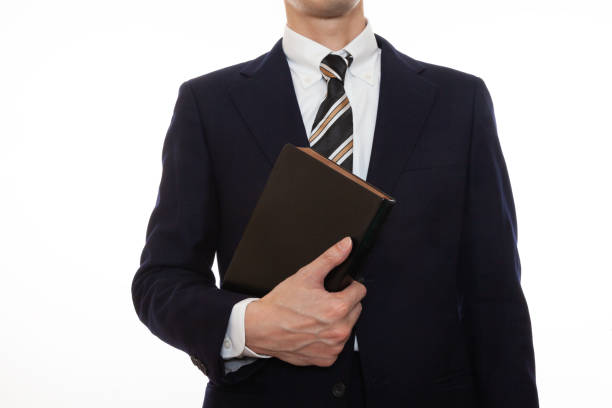 istock A man in a suit holding a book 1309572331