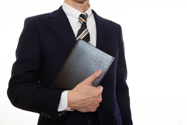 istock A man in a suit holding a book 1309573612