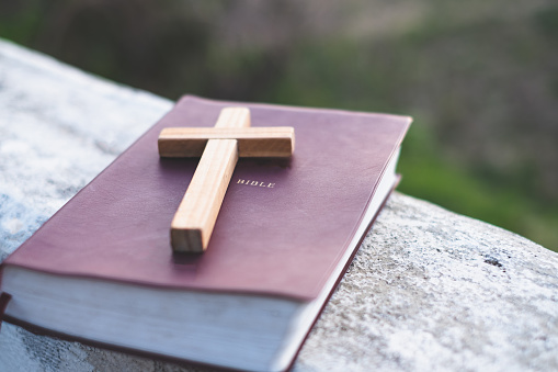 The crucifix is placed in the middle of the Bible. The idea of asking blessings from God with the power and power of holiness, which brings luck and shows forgiveness with the power of religion,faith.