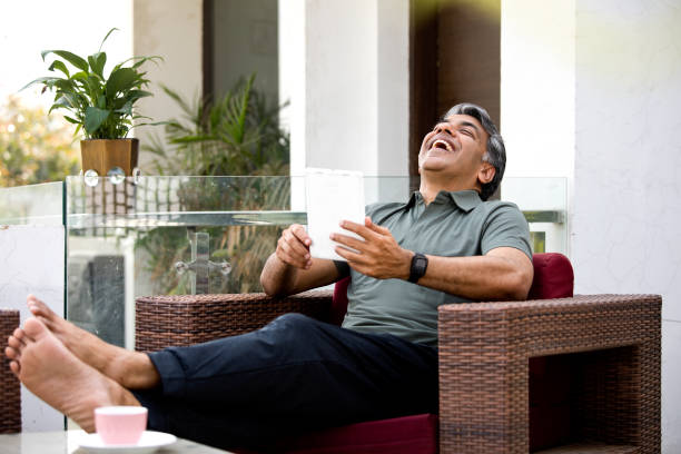 istock Happy man watching media content on digital tablet on armchair 1309576026