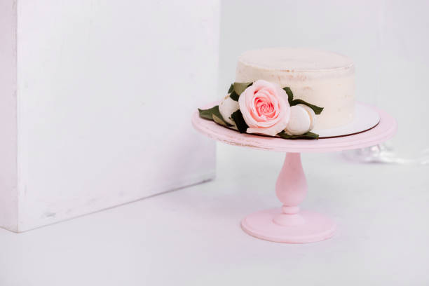 istock Beautiful white cream cake decorated with 2 year old candle and roses in white studio. Birthday party - Concept of a year of birth, party, celebration of life and memorable moments. 1309576191