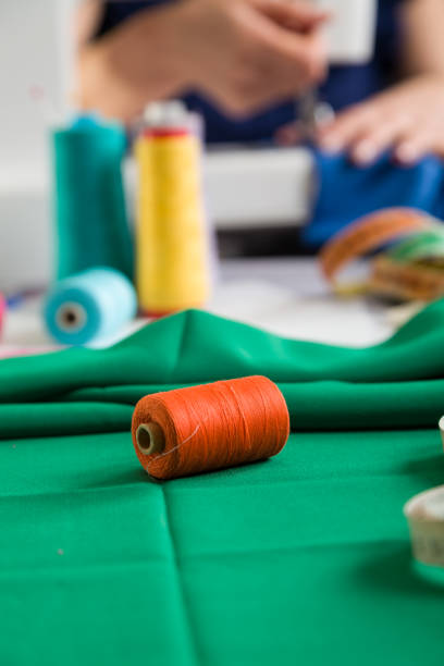 istock Sewing workshop. Sewing clothes. Closeup on a spool of thread. Photographic concept. 1309578434