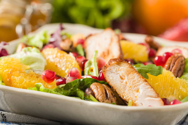 istock Spring salad with chicken, pomegranate, orange, pecan nuts and honey. 1309579664