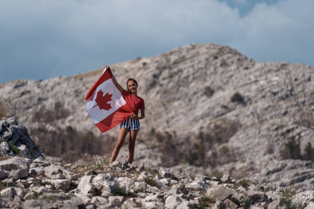 Child teenager girl holding a Canada flag Child teenager girl holding a Canada flag on of the mountain citizenship photos stock pictures, royalty-free photos & images