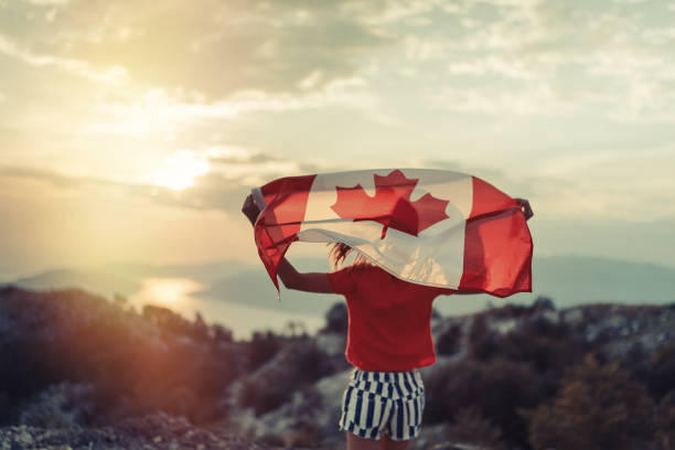 teenager-mädchen schwenkt die flagge von kanada beim laufen - canada day fotos stock-fotos und bilder