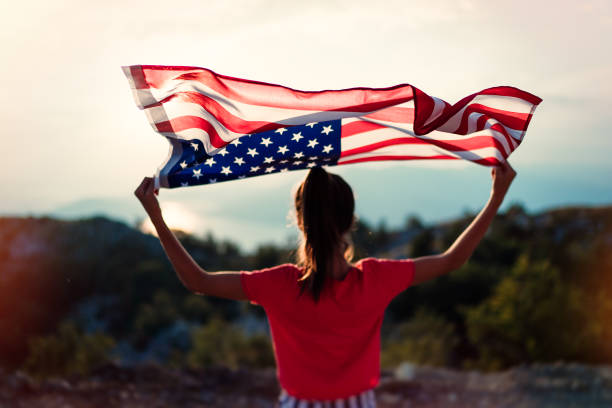 la fille d’adolescent agite le drapeau américain au-dessus de la montagne au fond de ciel - child flag fourth of july little girls photos et images de collection