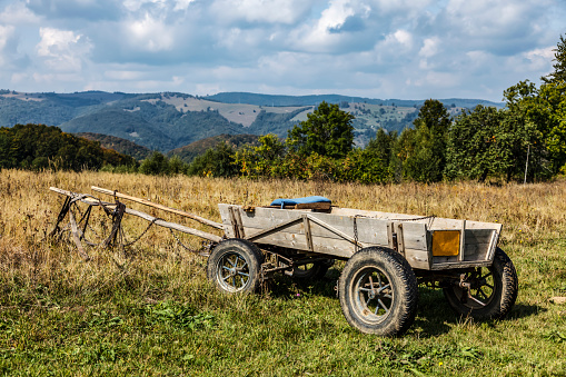 Image of a wooden wagon in a rural mountainous area.