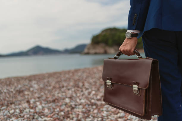 istock Businessman holding in hand briefcase 1309580472