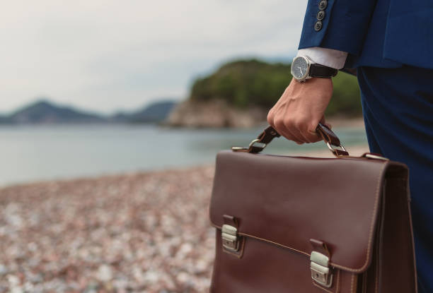 istock Businessman holding in hand briefcase 1309580531