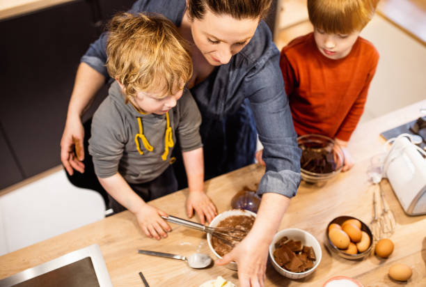 istock Kids helping their mother make muffins 1309581759