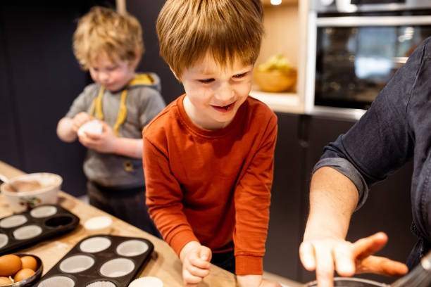 istock Kids helping their mother make muffins 1309581786