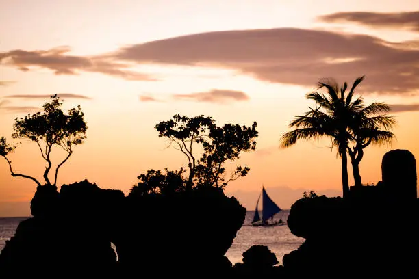 famous willys rock silhouette at sunset in boracay island, the philippines.