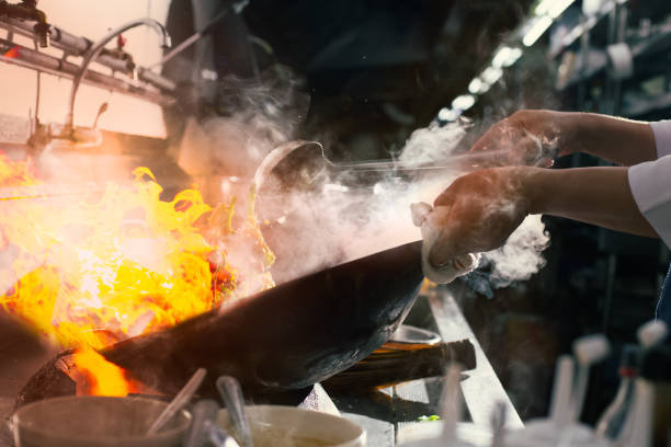 istock Chef stir fry busy cooking in kitchen 1309588775