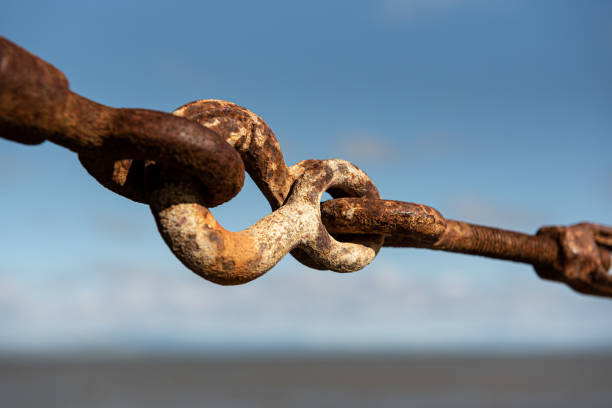 Thurnbuckle against blue sky Traditional, old, rusty turnbuckle at a pier, viewed from close, against blue sky rusted chain stock pictures, royalty-free photos & images