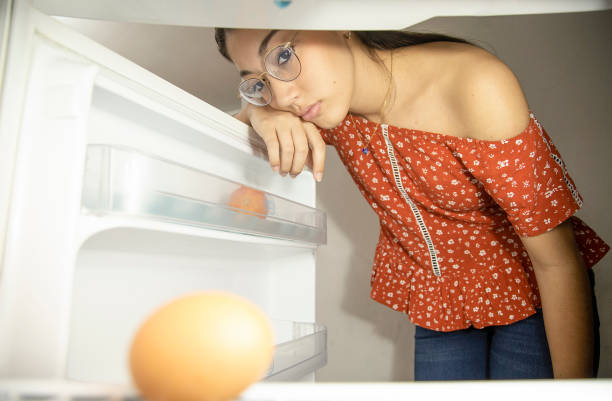 istock woman looking at the bottom of the empty fridge 1309592659