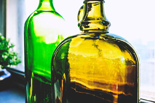 close-up of vibrant yellow and green bottles near the window