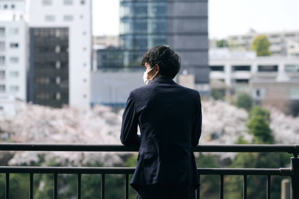 Rear view of contemplating businessman City of Springtime in new normal. fruit tree flower sakura spring stock pictures, royalty-free photos & images