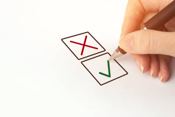 istock Hand with black pen choosing one of two options answer. Person Marking in a Checkbox. 1309596061
