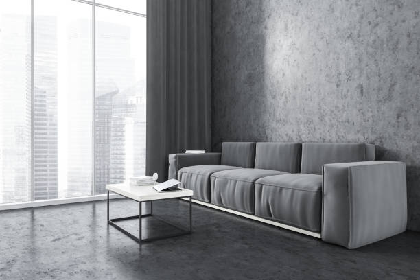 istock Grey sofa in living room near window and grey wall with coffee table 1309596067