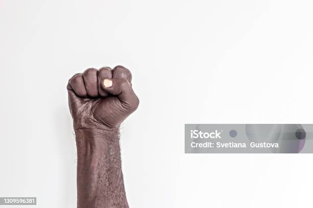 Male Hand Clenched Into A Fist On A White Background A Symbol Of The Struggle For The Rights Of Blacks In America Protest Against Racism Stock Photo - Download Image Now