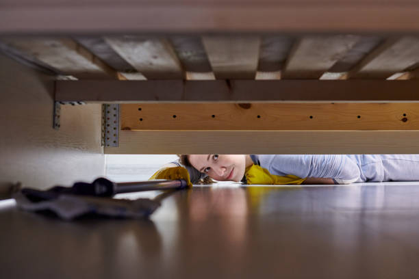istock Woman cleaning floor under bed using flat wet mop. 1309597500