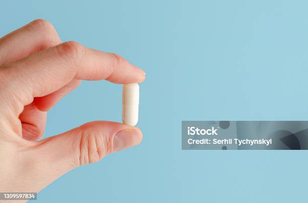 Female Hand Holding White Capsule Stock Photo - Download Image Now - Capsule - Medicine, Pill, White Color