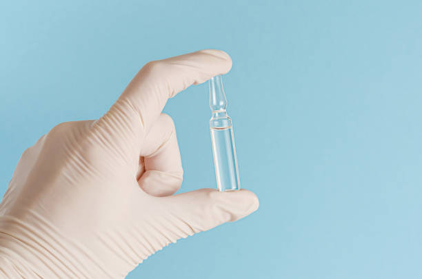 istock Hand in glove holding ampoule 1309598848