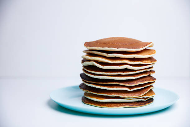 istock Stack of Tasty pancakes on white background 1309600127