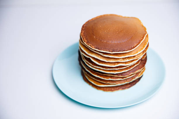 istock Stack of Tasty pancakes on white background 1309600250