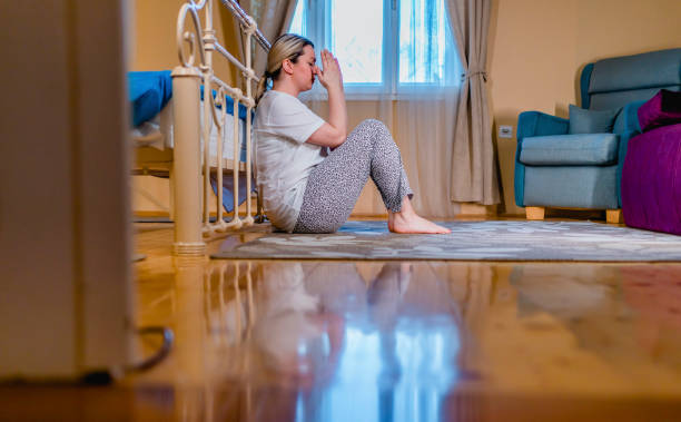 istock Depressed woman sitting on the floor 1309604466