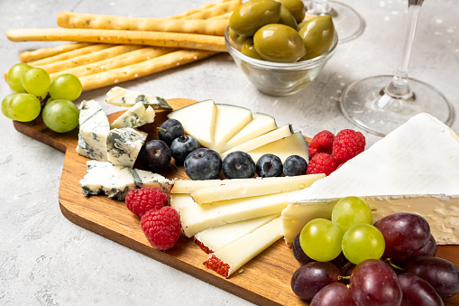 Set Italian or French cheeses parmesan, pecorino, gorgonzola cheese and berries, olives and and grissini breadsticks. Top view. appetizers antipasti for an aperitif with prosecco and white wine