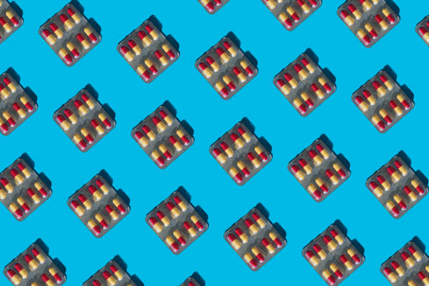 istock Package of red-yellow pils lay out on blue background, minimal concept pattern 1309607866
