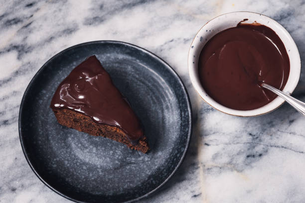 fotografii de stoc, fotografii și imagini scutite de redevențe cu tort choclate cu glazură choclate întuneric pe marmură - chocolate icing
