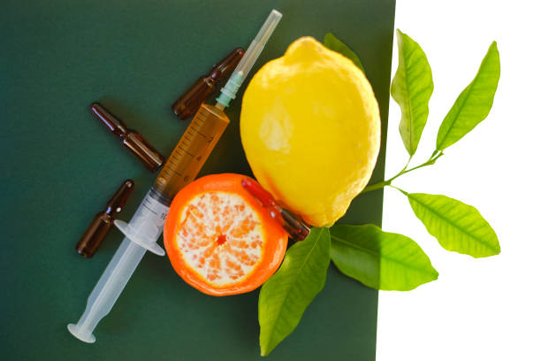 Vitamin C. Serum with Vitamin C. ampoules close-up set, syringe with injection solution and lemons fruits on green background isolated on white background.Beauty and health
