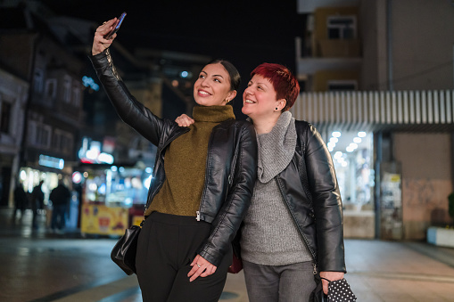 Young woman and her mother take selfies
