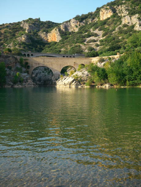 A vertical shot of the arched stone bridge over the river in Saint-Guilhem-le-Desert