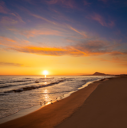 Denia beach and Montgo sunrise on Mediterranean sea from Las Marinas in Oliva Beach area of Valencia and Alicante at Spain