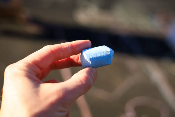 istock Hand holding a piece of blue chalk 1309614414
