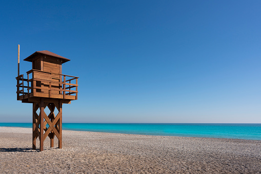 Sagunto Canet beach in Valencia with baywatch tower in blue summer sky day by Mediterranean sea