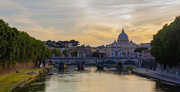 A suggestive cityscape with an idyllic sunset in the golden hour along the Tiber river, in the historical and baroque heart of Rome. On the horizon the Mausoleum of Augustus and Ponte Sant'Angelo. In 1980 the historic center of Rome was declared a World Heritage Site by Unesco. Super wide angle image in 16:9 and high definition format.