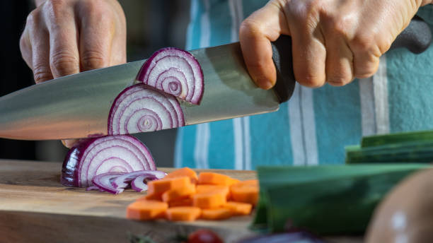 istock Male hands cutting onion in kitchen. Using sharp knife to prepare vegetable. 1309616498