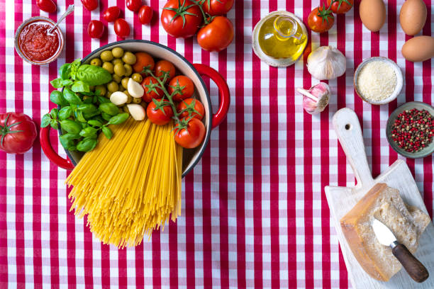 istock Spaghetti basil tomato garlic and olives in pot on gingham tablecloth 1309617523