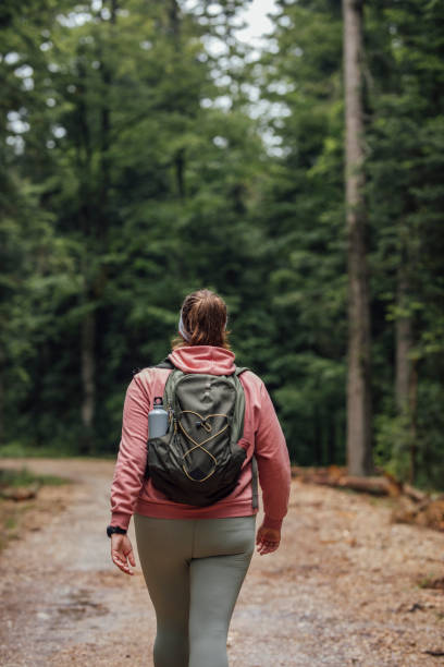 istock Plus Size Woman With a Backpack Walking in Nature Alone (a Back View) 1309618728